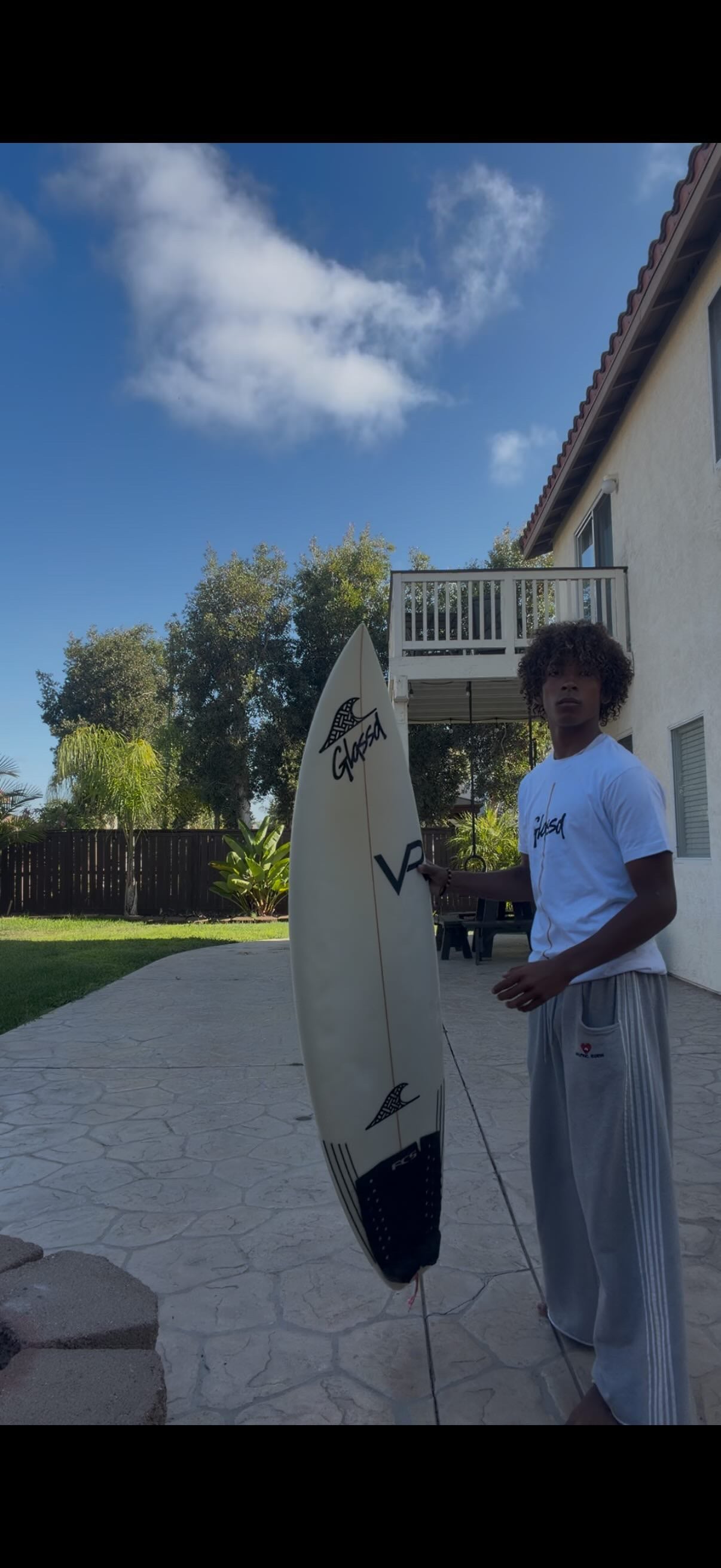 Glassd Board Tee in white worn with a Glassd surfboard