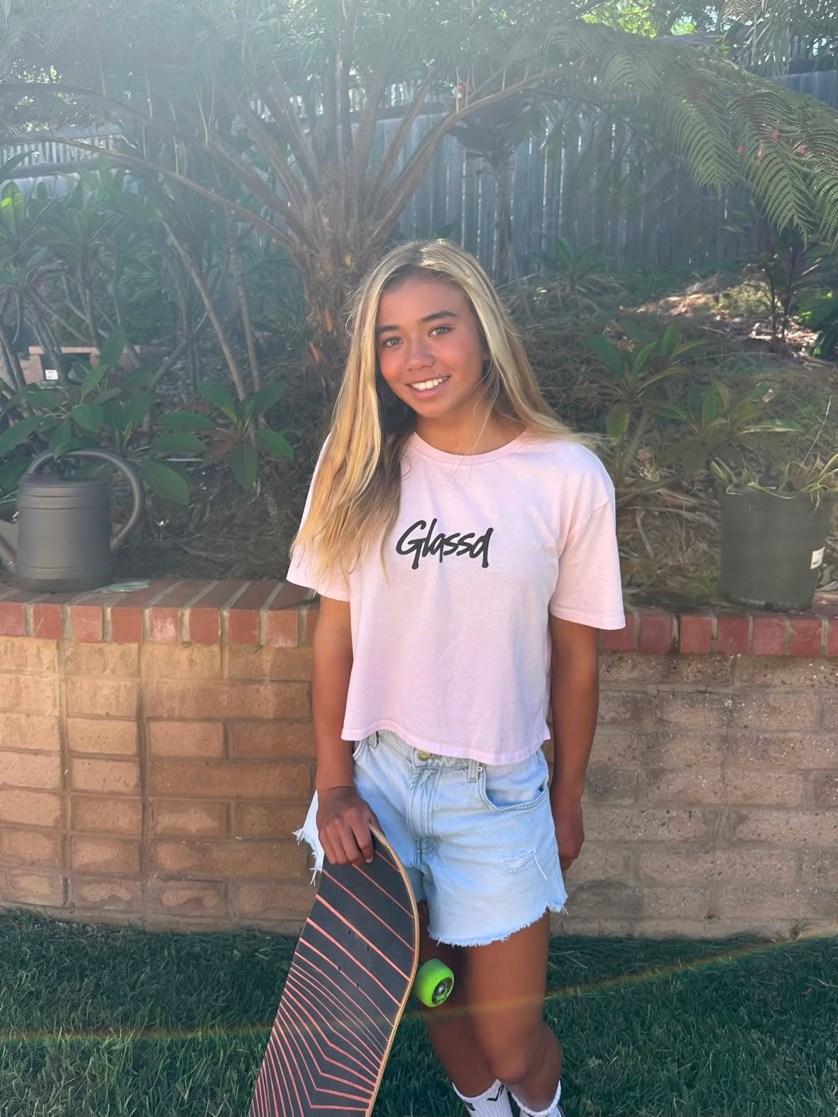 Glassd Daily Crop Tee in pink worn with a skateboard