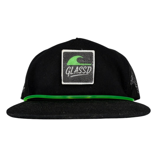 The Glasser, black GLASSD hat with handmade fiberglass patch and green surfboard leash over the bill